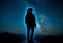 Técnica de relajación de la Luz Azul Mujer con un aura azul en lo alto de una montaña por la noche y con cielo estrellado