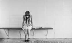 Las heridas emocionales afectan tu abundancia Mujer sentada en un banco y con heridas emocionales