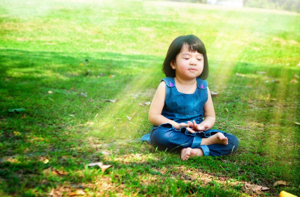 niña en un parque meditando