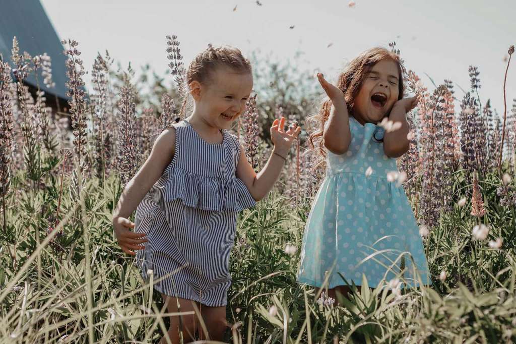 Dos niñas en un campo riendose.
