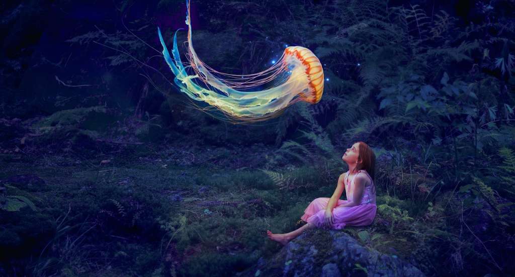 Una niña en la naturaleza viendo volar una medusa de colores.