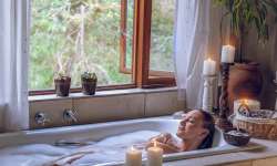 Cómo tomar un baño de Limpieza espiritual Mujer en una bañera con velas realizando un baño de limpieza espiritual