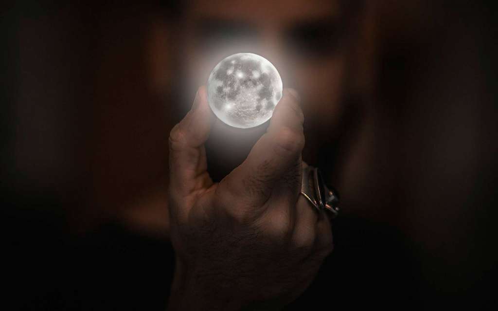 Hombre con una luna en su mano.