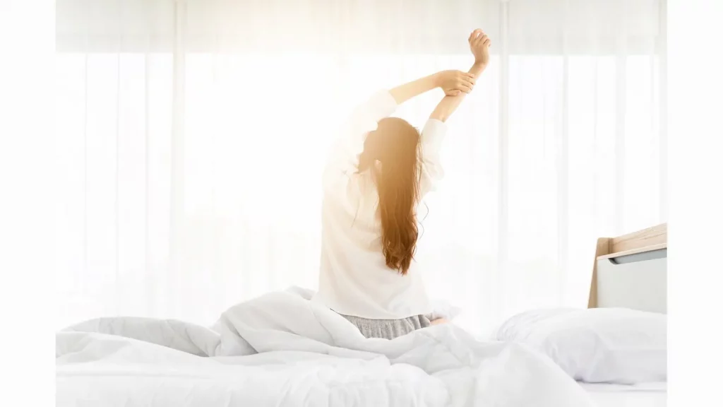 Mujer levantandose por la mañana de la cama