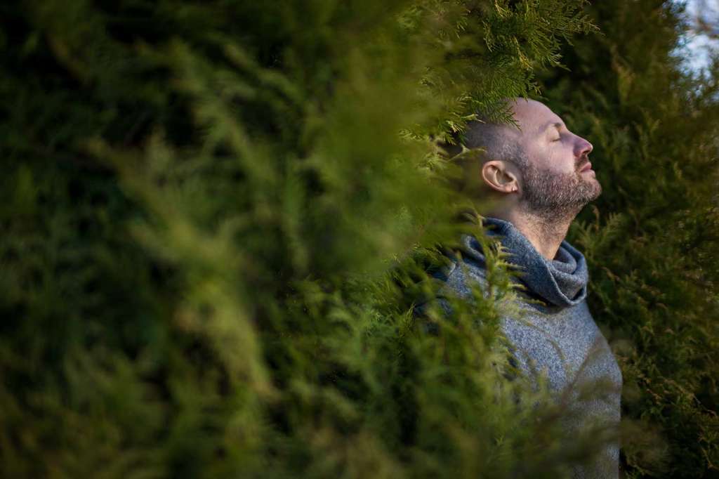 Un hombre respirando en un bosque practicando una de las maneras de meditar