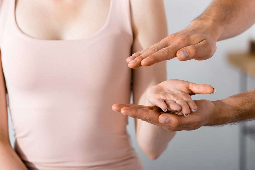 Las manos de un hombre y una mujer practicando el percibir la energía