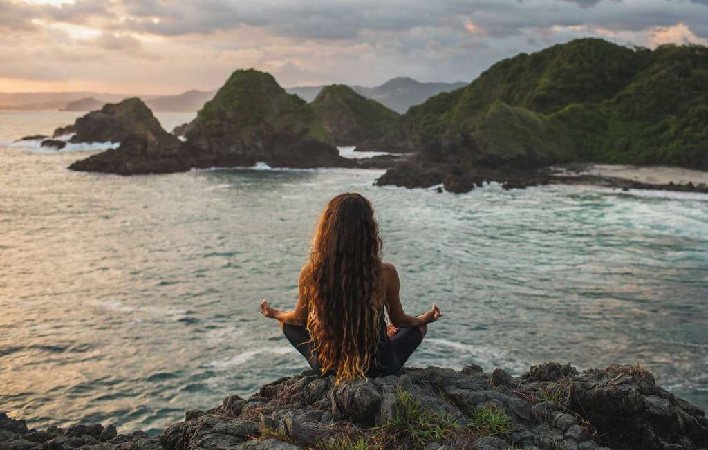 Mujer meditando en el mar y el despertar espiritual