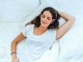 Una mujer tumbada en la cama practicando la meditación del body scan
