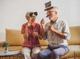 Dos personas mayores disfrazándose y riéndose y la química del cerebro y la felicidad