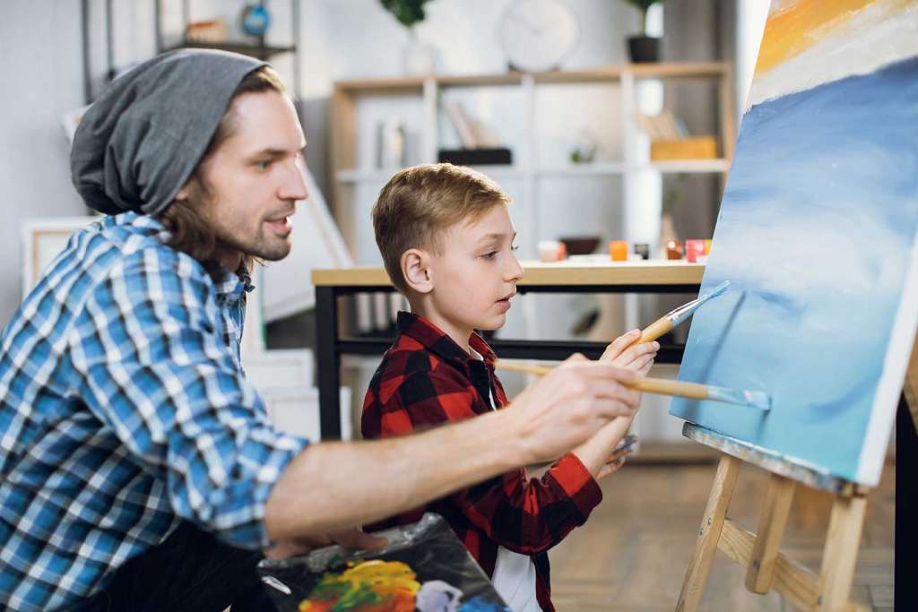 Padre e hijo pintando un cuadro azul