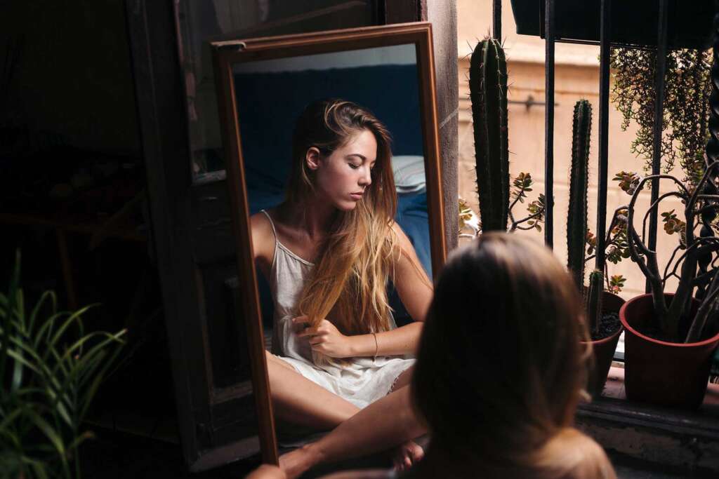 Mujer mirándose en un espejo y el yo idea