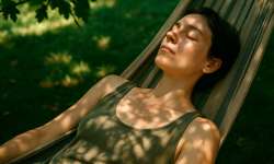 Curso Consciencia – Día 25: Espacios de no hacer Mujer tumbada en una hamaca con los ojos cerrados completamente en quietud.